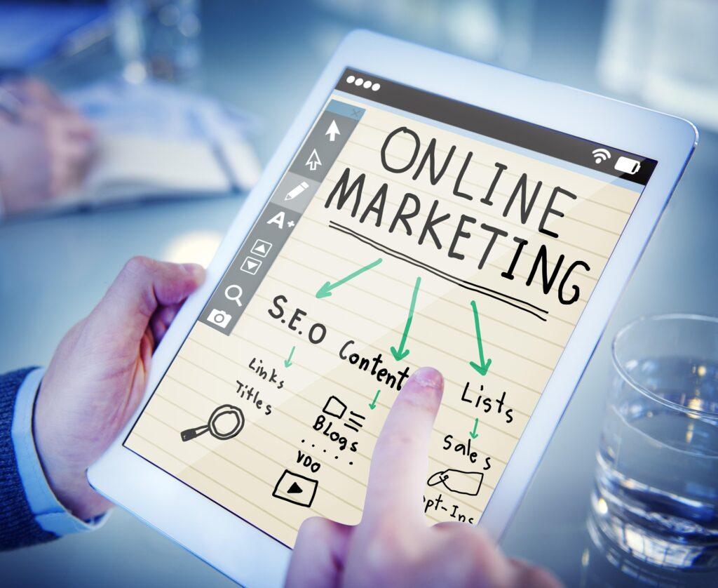 A hand points to a tablet showing an ONLINE MARKETING diagram with S.E.O, Content and Lists branches.